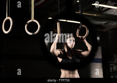 Bestimmt Athlet Ausübung auf Gymnastik Ringe an Health Club Stockfoto