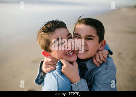Hohen winkel Portrait von glücklichen Brüder am Strand stehen Stockfoto