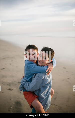 Portrait von Jungen, die gerne Bruder beim Stehen am Strand Stockfoto