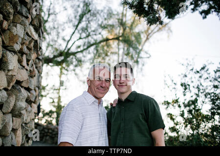 Low Angle Portrait von Vater mit Sohn gegen Himmel im Park bei Sonnenuntergang Stockfoto