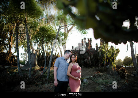 Romantisches Paar standing in Park bei Sonnenuntergang Stockfoto