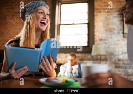 Frau mit digitalen Tablet und genießen mit Freunden Stockfoto