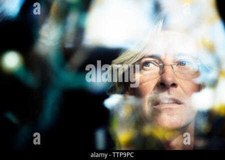 Close-up von nachdenklich älterer Menschen durch die Glasfenster zu sehen Stockfoto