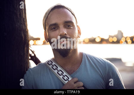 Portrait von zuversichtlich Mann stand am See gegen den klaren Himmel Stockfoto