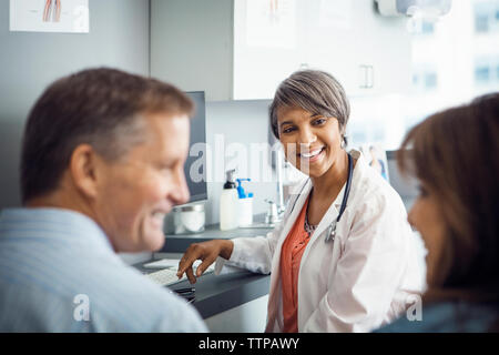 Gerne Ärztin auf Paar in Klinik Stockfoto