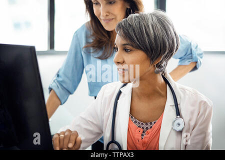 Ärztin mit Computer mit Patienten in der Klinik Stockfoto