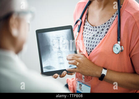 Mittelteil der weiblichen Doktor x - ray auf Tablet-PC zu Patient Stockfoto