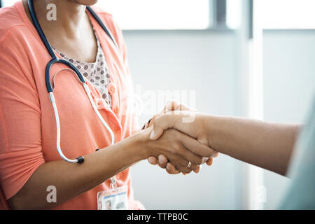 Mittelteil der weiblichen Arzt Händeschütteln mit Patienten Stockfoto