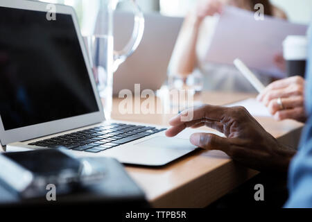 Zugeschnittenes Bild der Geschäftsmann mit Laptop im Büro Stockfoto