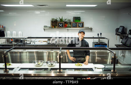 Porträt Lächeln Chef steht in der gewerblichen Küche Stockfoto