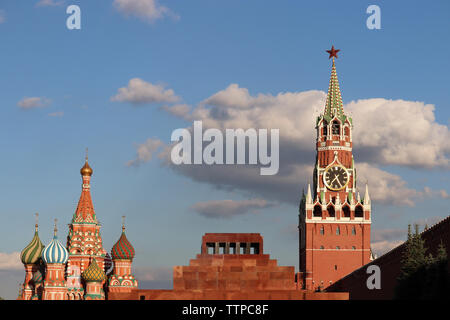 Blick auf den Kreml, die Basilius-Kathedrale und Lenin Mausoleum auf dem Roten Platz in Moskau. Spasskaja Turm gegen den blauen Himmel mit Wolken Stockfoto