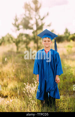 Portrait von Happy Boy an der Staffelung Kleid stehend auf dem Feld Stockfoto