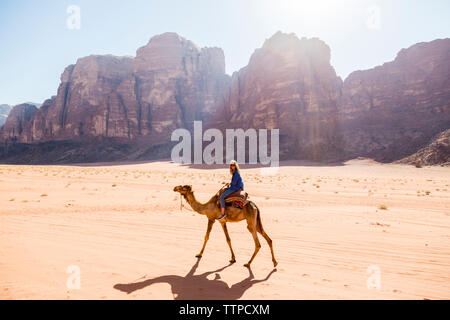 Frau reiten auf dem Kamel in der Wüste Stockfoto