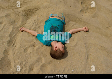 Hohe Betrachtungswinkel und der Boy in Sand am Strand begraben Stockfoto