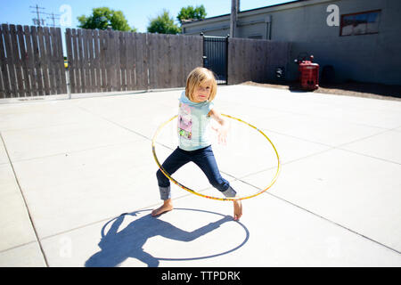 Portrait von Mädchen spielen mit Hula Hoop am Spielplatz im Sommer Stockfoto