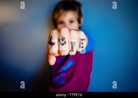 In der Nähe von Mädchen, Finger mit Liebe Text beim Stehen durch die Wand zu Hause Stockfoto