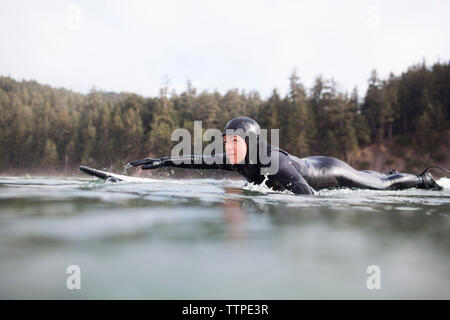 Seitenansicht des liegende Frau auf Surfbrett im Meer Stockfoto