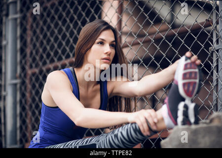 Bestimmt weiblichen Athleten stretching Bein im Freien Stockfoto