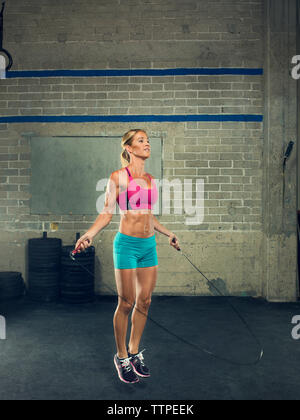 Zuversichtlich weiblichen Athleten überspringen im Fitnessstudio Stockfoto