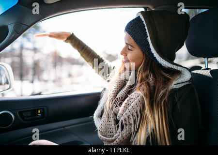 Glückliche junge Frau im Auto im Winter genießen. Stockfoto