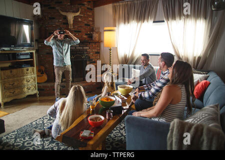 Gerne Freunden, bei der man während des Spielens heads up Spiel während der Veranstaltung zu Hause Stockfoto