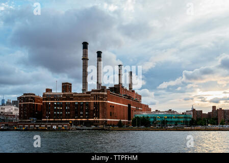 Werk von East River in Stadt gegen bewölkter Himmel Stockfoto