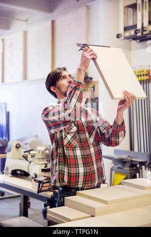 Konzentriert man messen Holzbrett in der Werkstatt Stockfoto