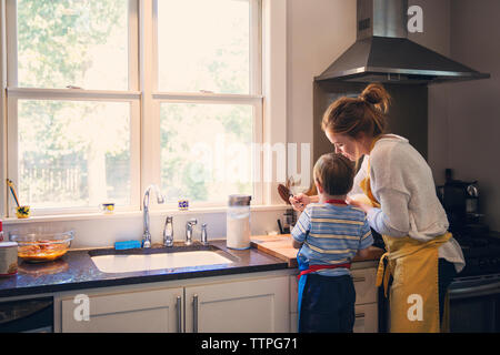 Hintere Ansicht von Mutter und Sohn und Kochen in der Küche Stockfoto