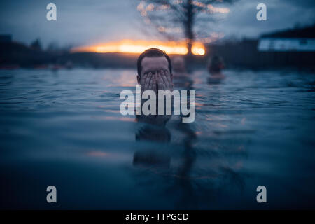 Mann, die seine Augen Im Wasser an die Geheime Lagune in Island Stockfoto