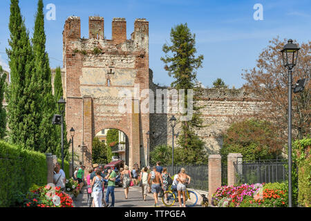 LAZISE, Gardasee, Italien - September 2018: Menschen zu Fuß in die Stadt vorbei an der alten Stadtmauer in Lazise am Gardasee. Stockfoto