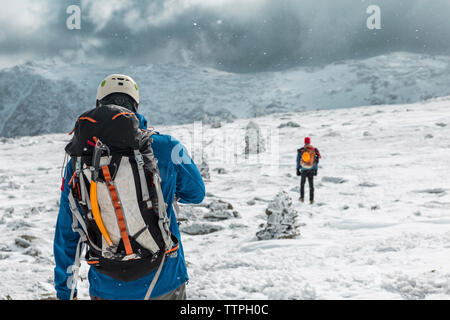 Ansicht der Rückseite des Backpackers auf verschneite Landschaft bei Unwetter am Weißen Berge Stockfoto