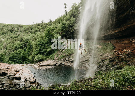 Ein Mann rappels ein Wasserfall in der Catskills, New York, New England Stockfoto