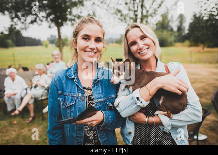 Portrait von Freunden mit Chihuahua stehend im Hof Stockfoto