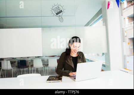Lächelnden jungen Hispanic Frau Arbeiten am Laptop Stockfoto