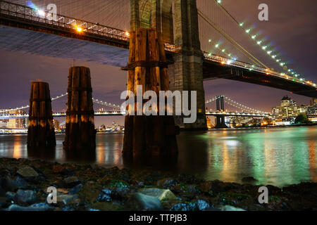 Beleuchtete Brücken über den East River bei Nacht Stockfoto