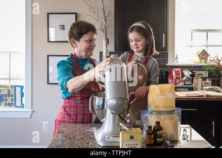 Großmutter und Enkelin, die Cookie Teig mit elektrischen Mixer in der Küche zu Hause. Stockfoto