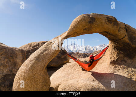 Frau entspannen auf der Hängematte aufhängen von Rock Formation Stockfoto