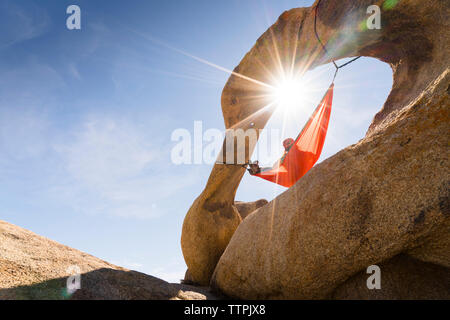 Low Angle View von Frau entspannen auf der Hängematte aufhängen von Rock Formation Stockfoto