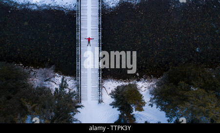 Mitte der Abstand der Wanderer liegen auf Fußgängerbrücke in Wald im Winter Stockfoto