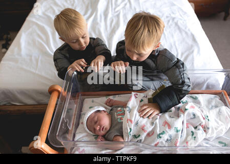 Hohe Betrachtungswinkel der Brüder, Baby Mädchen schlafen in der Krippe suchen Stockfoto