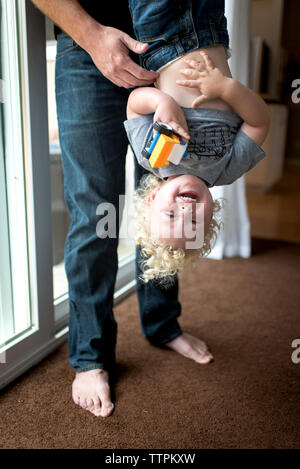 Untere Partie der Vater die fröhlichen Sohn auf den Kopf zu Hause Stockfoto