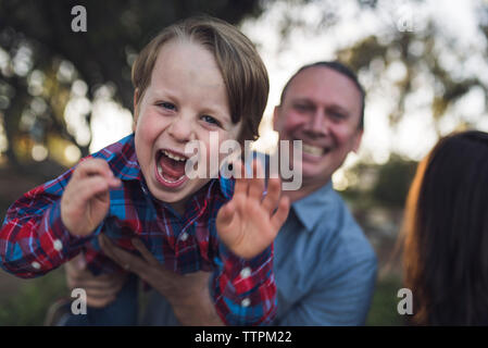 Portrait von verspielten Sohn von Vater im Park durchgeführt Stockfoto
