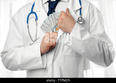 Arzt, Geld in seiner Manteltasche closeup Stockfoto