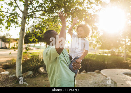 Happy Sohn hohe fünf- bis Vater im Park Stockfoto