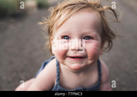 Close-up Portrait von nett lächelnden Mädchen sitzen auf der Straße im Wald Stockfoto