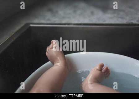 Niedrige Abschnitt von nassen baby boy liegend in der Badewanne zu Hause Stockfoto