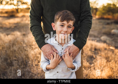 Nahaufnahme von Jungen durch Vater in Kalifornien Feld umfaßt wird Stockfoto