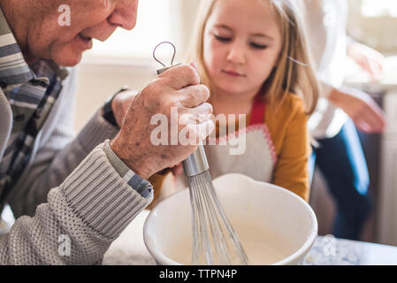 Mädchen und granddfather Frühstück machen Pfannkuchen in der Küche Stockfoto