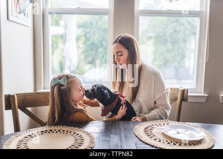 Mehr-generationen-Familie und kleiner Hund essen Pfannkuchen zum Frühstück Stockfoto