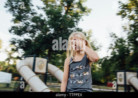 Mädchen mit geschlossenen Augen gegen Himmel in Spielplatz Stockfoto